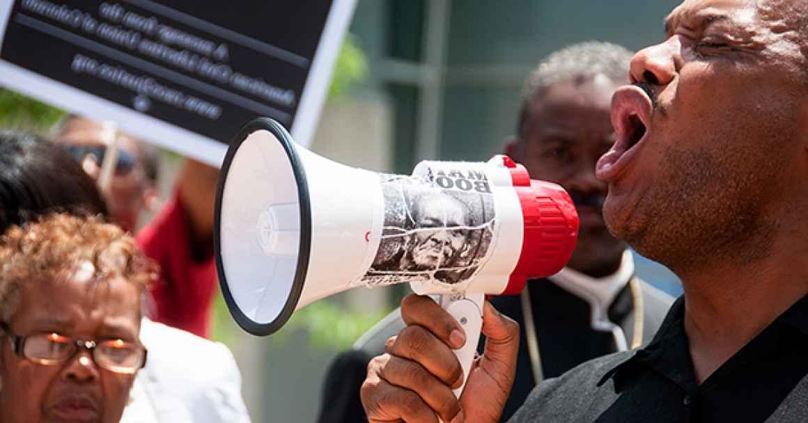 A man with a megaphone at a protest for racial justice